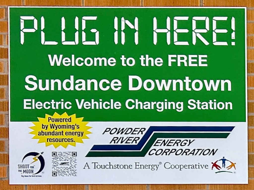 sign: Plug In Here! Welcome to the FREE Sundance Downtown Electric Vehicle Charging Station. Powder River Energy Corporation
